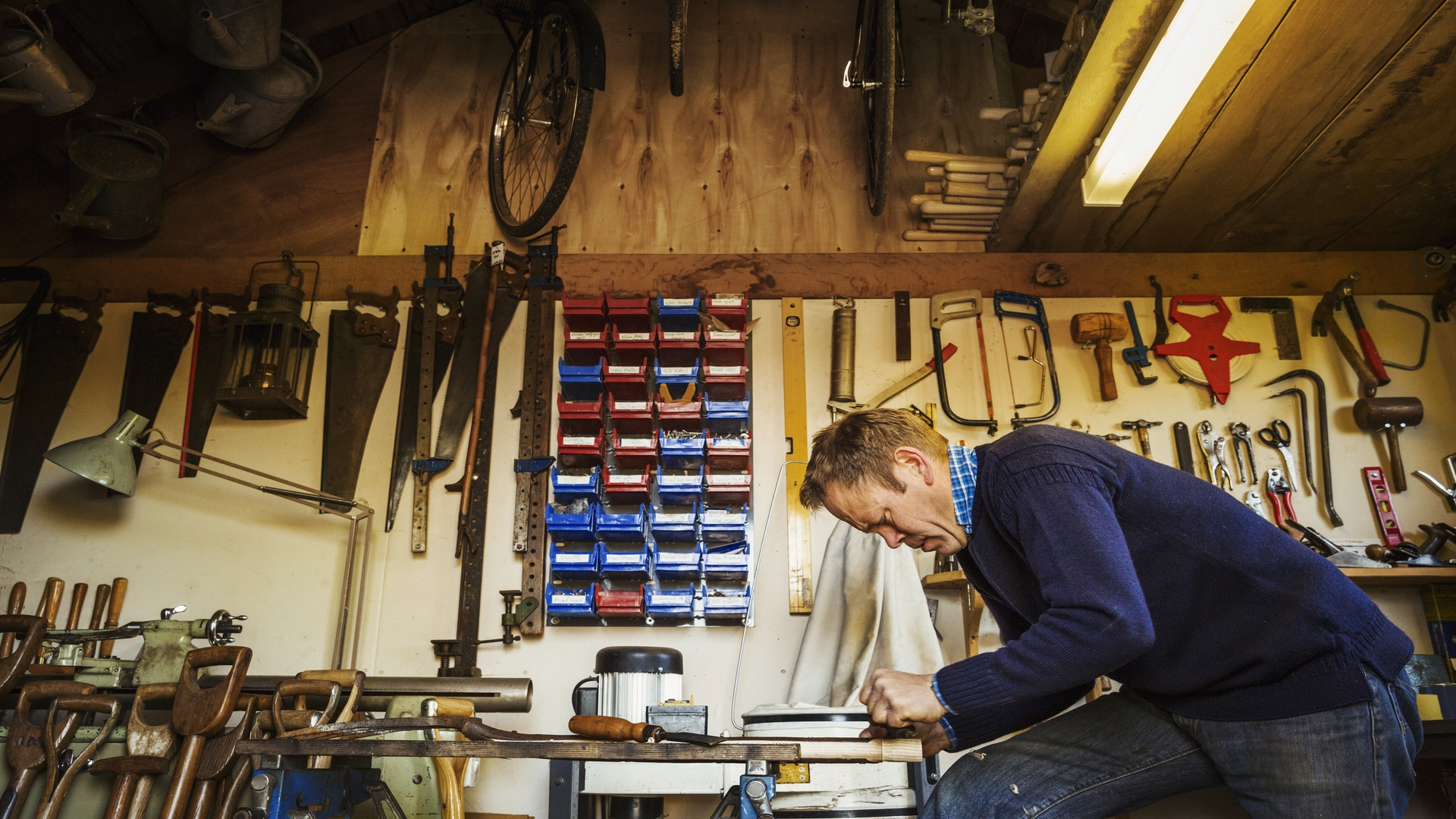 Man in his workshop with various tools to create basement support beams