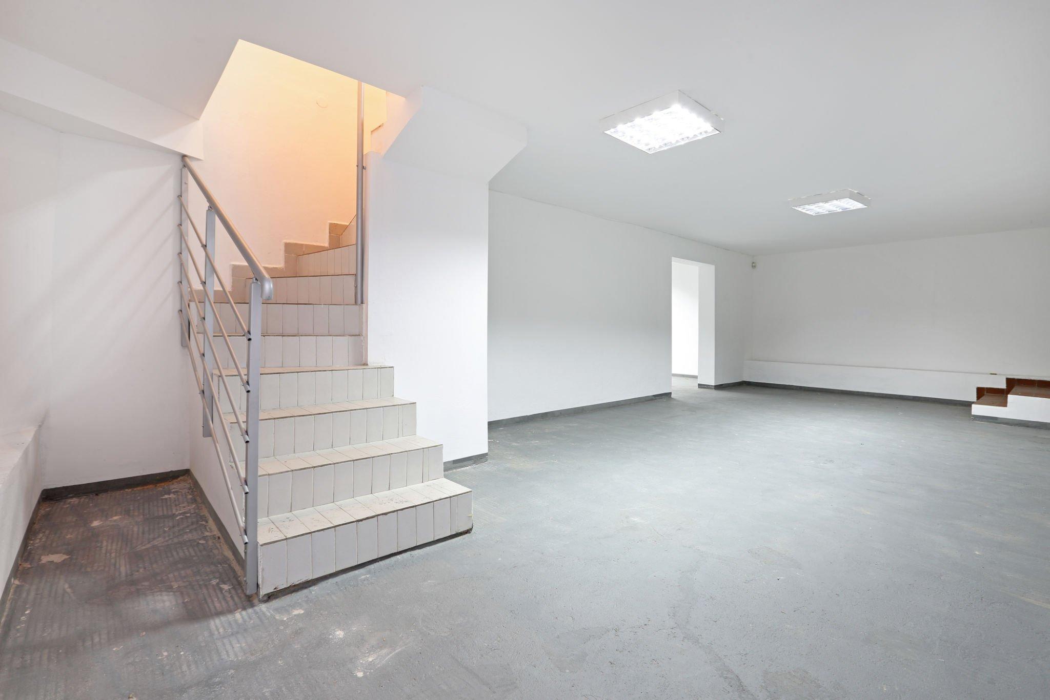barndominium with basement : A white empty basement with stairs to utilize for anything